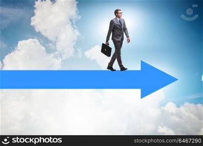 Businessman walking on arrow in business concept