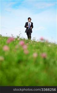 Businessman walking on the meadow