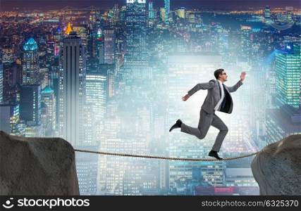 Businessman walking on tight rop in business concept