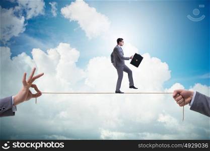 Businessman walking on tight rope in business concept