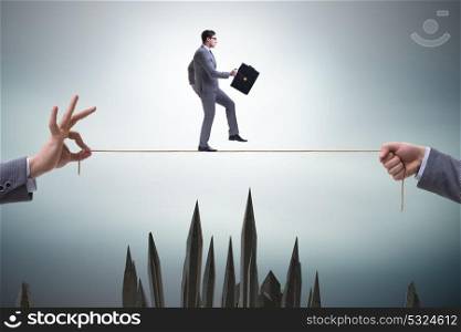 Businessman walking on tight rope in business concept