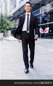 Businessman walking outdoors in city business district. Aimed to success in business