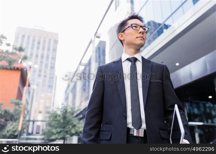 Businessman walking outdoors in city business district. Aimed to success in business
