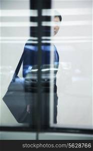 Businessman walking with briefcase in parking garage, white background