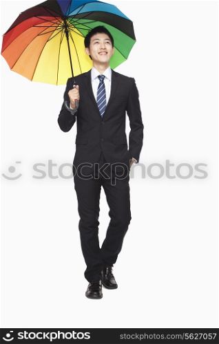 Businessman walking with colorful umbrella