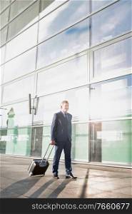 Businessman walking with his suitcase in the airport