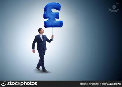 Businessman walking with inflatable british pound sign