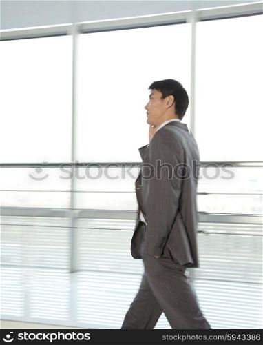 Businessman walking with mobile phone