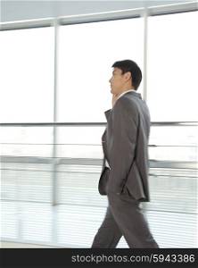 Businessman walking with mobile phone