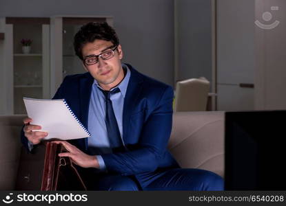 Businessman watching tv at night late