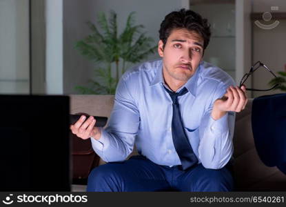 Businessman watching tv at night late