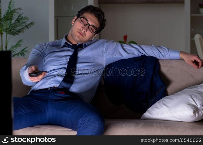 Businessman watching tv at night late