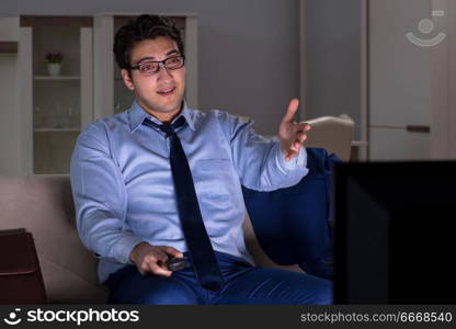 Businessman watching tv at night late