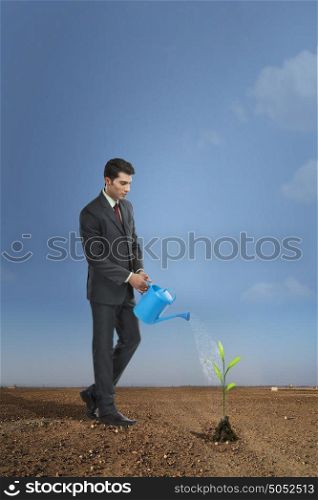Businessman watering a plant