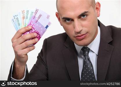 Businessman waving a wad of Euros