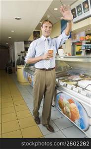 Businessman waving in an office cafeteria