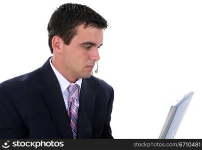 Businessman wearing a headset and working on a laptop