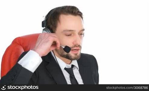Businessman wearing a headset concentrating as he listens to a call conceptual of a help desk, call centre operator or client services