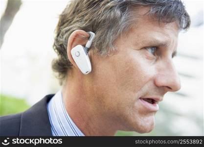 Businessman wearing earpiece outdoors