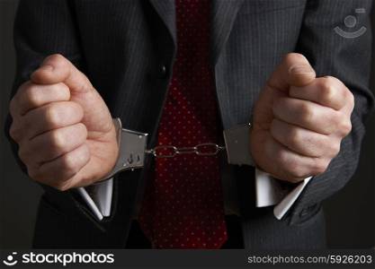 Businessman Wearing Handcuffs Illustrating Corporate Crime