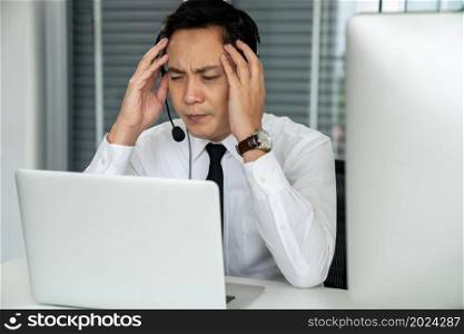 Businessman wearing headset working actively in office . Call center, telemarketing, customer support agent provide service on telephone video conference call.. Businessman wearing headset working actively in office