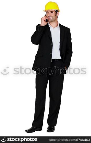 businessman wearing helmet and talking on his cell