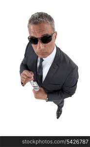 businessman wearing sunglasses holding money and smoking a cigar