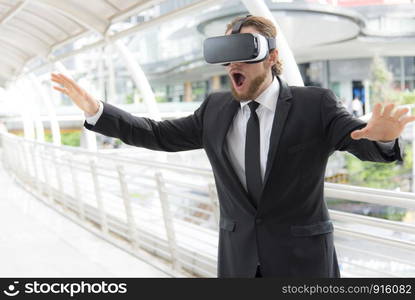 Businessman wearing virtual reality goggle glasses and enjoying in this activity, future technology concept, imagine concept