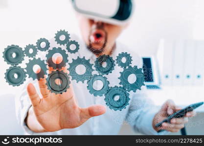 businessman wearing virtual reality goggles in modern office with mobile phone using with VR headset with 3d gear of success