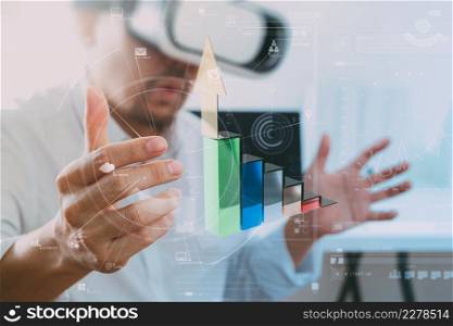 businessman wearing virtual reality goggles in modern office with mobile phone using with VR headset with VR chart and graph with icon