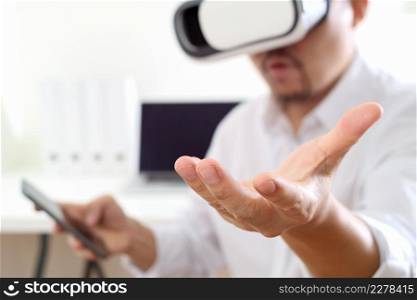 businessman wearing virtual reality goggles in modern office with mobile phone using with VR headset