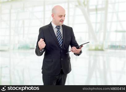 businessman winning, using touch pad of tablet pc, at the office