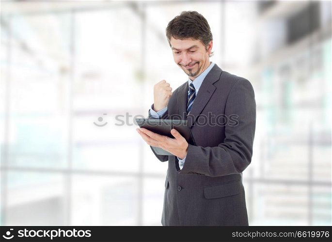 businessman winning, using touch pad of tablet pc, at the office