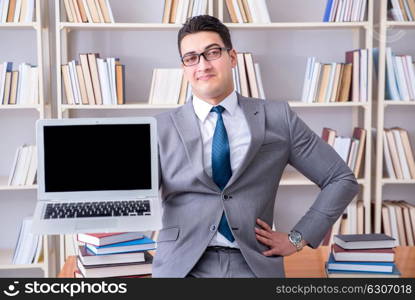 Businessman with a blank screen laptop working in the library