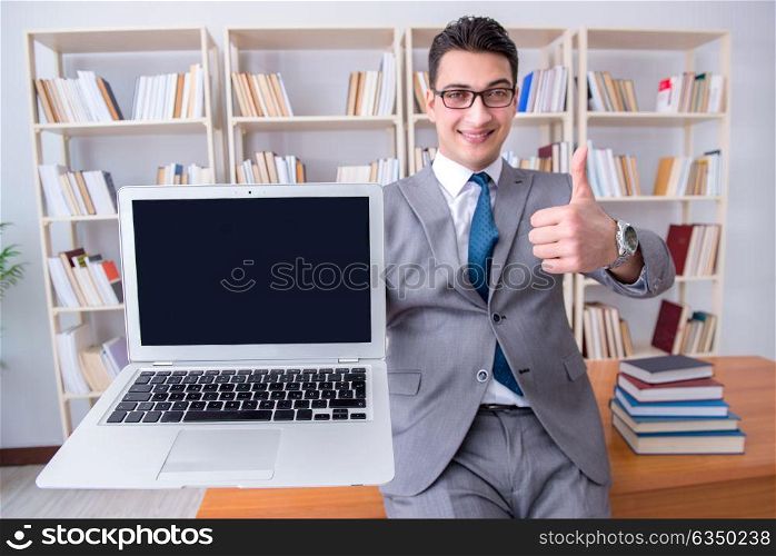 Businessman with a blank screen laptop working in the library