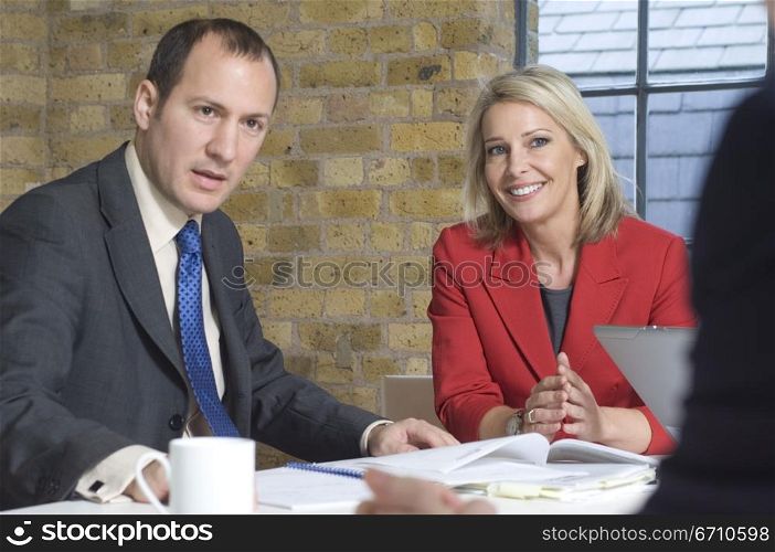 Businessman with a businesswoman sitting at a table in a meeting