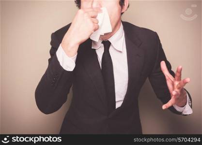 Businessman with a cold is sneezing