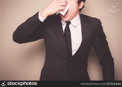 Businessman with a cold is sneezing