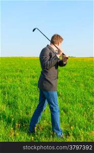 businessman with a golf club in the field