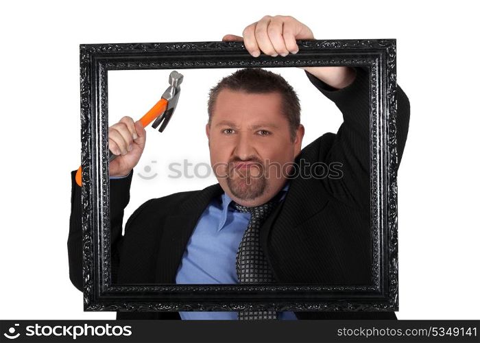 Businessman with a hammer and frame