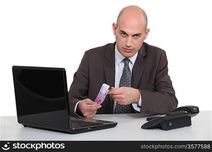 Businessman with a laptop and Euros