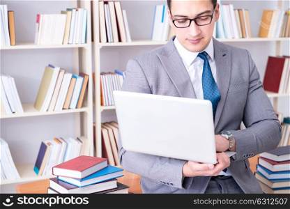 Businessman with a laptop working in the library