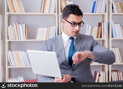 Businessman with a laptop working in the library