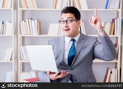 Businessman with a laptop working in the library