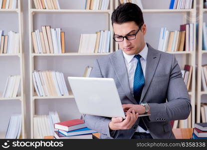 Businessman with a laptop working in the library