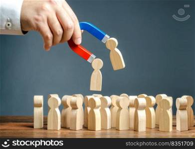 Businessman with a magnet pulling wooden figures of people from the crowd. Recruiting new workers, headhunters. Formation of a new business team of applicants. Personnel Management. Find the best.