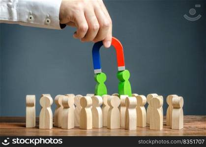 Businessman with a magnet pulls green figures of people out of the crowd. Recruiting new workers. Formation of a new business team of applicants. Search talented workers with great career potential