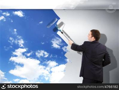 Businessman with a paint brush creating natural background