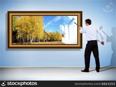 Businessman with a paint brush creating natural background