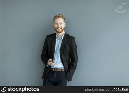Businessman with a phone by the wall